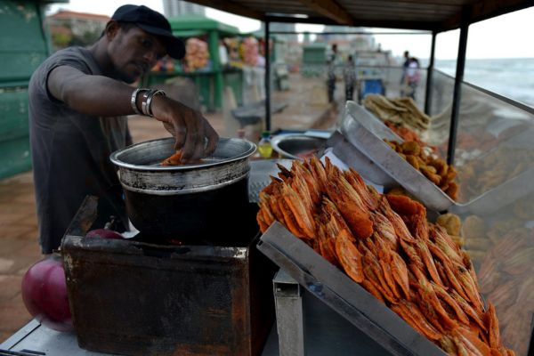 A-street-food-vendor-is-prepareing-a-local-delicacy-to-be-offered-to-a-customer-during-a-colombo-street-food-tour