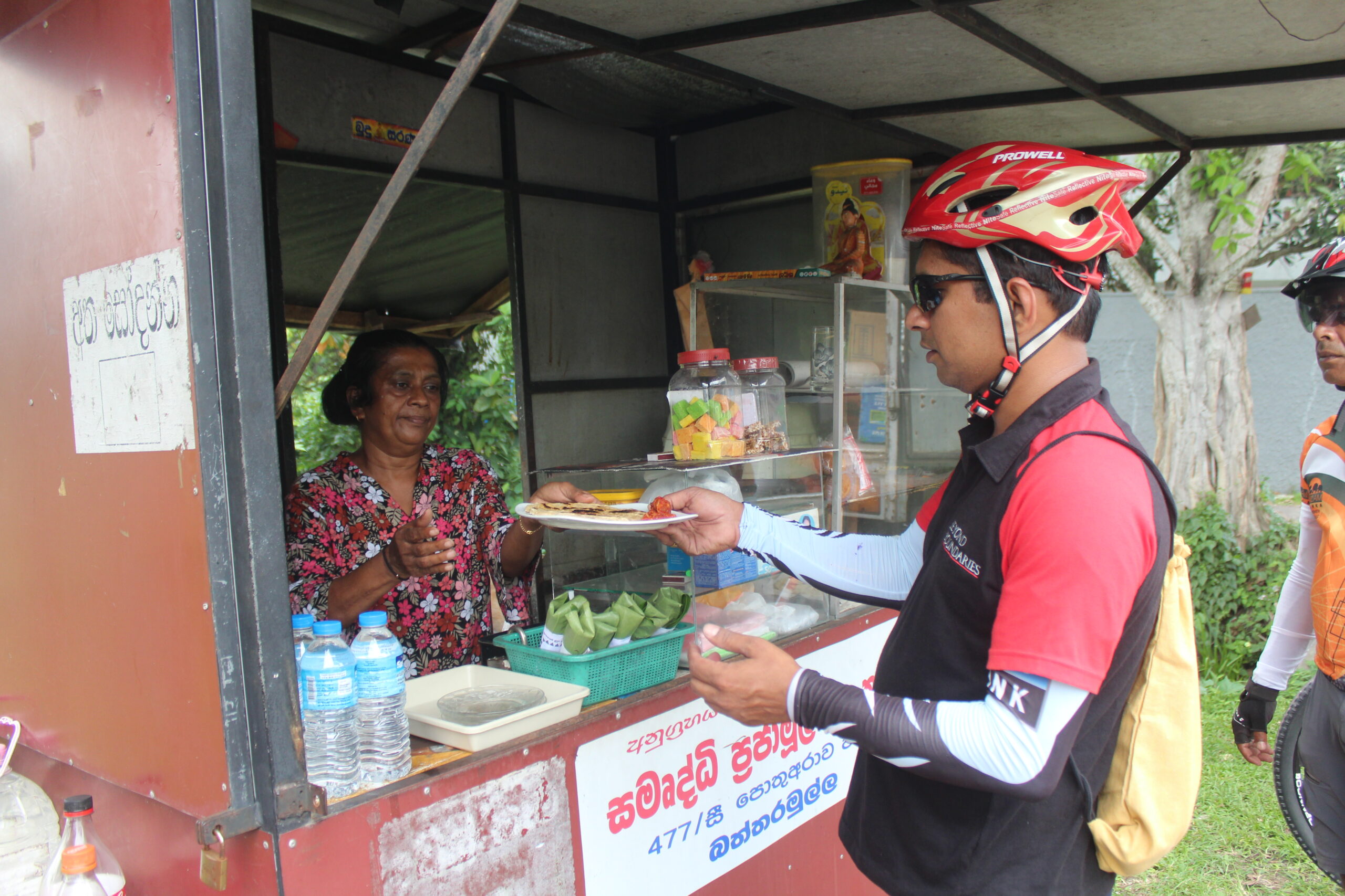 cycle rider buying foods from a lady