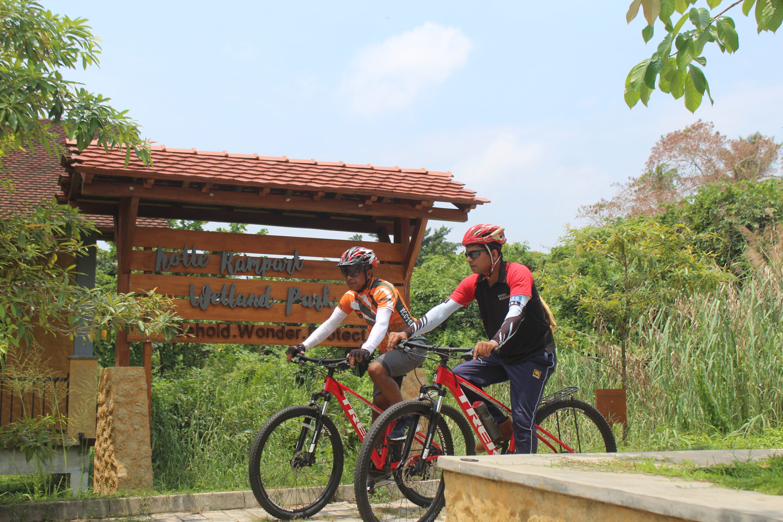 Two cycle riders at wetland park in Sri Lanka